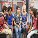 A group of tweens and teens sitting in a classroom